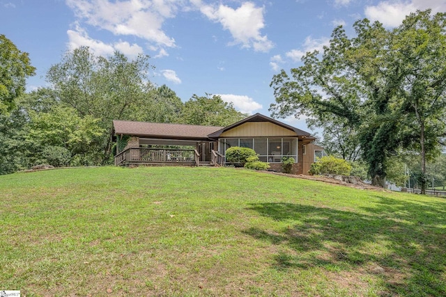 view of front facade featuring a front lawn and a wooden deck