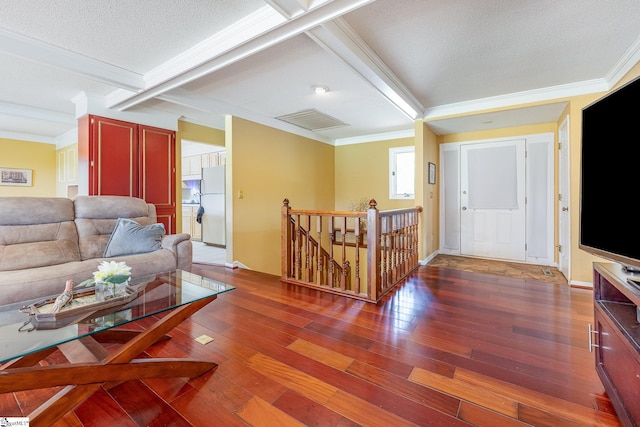 living room featuring dark wood-style flooring, visible vents, and crown molding