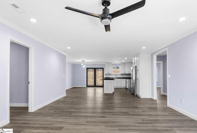 unfurnished living room featuring ornamental molding, hardwood / wood-style floors, and ceiling fan