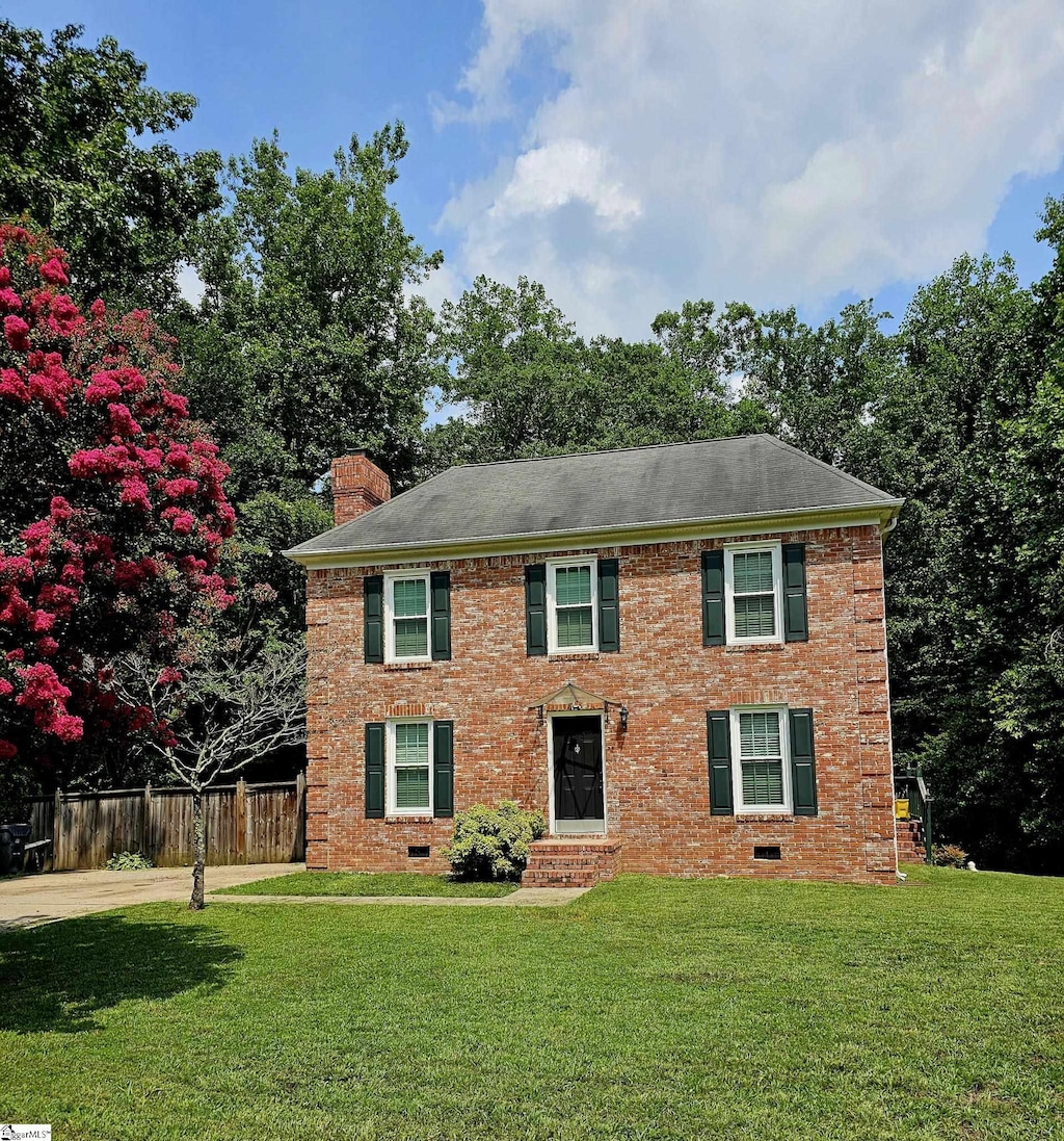 colonial inspired home with a front lawn