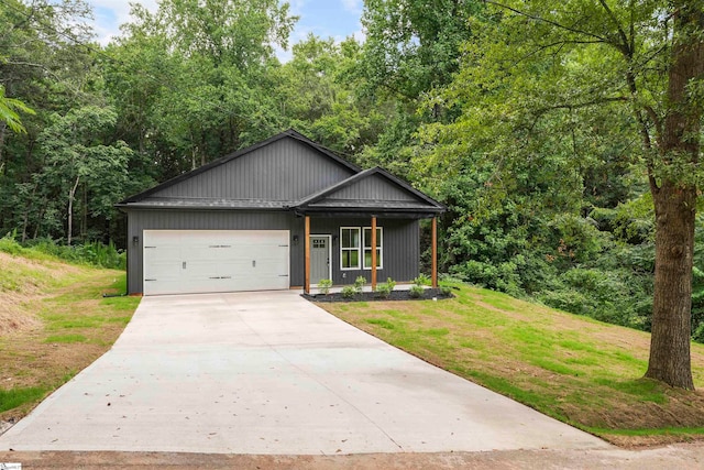 view of front of home with a porch, a garage, and a front yard