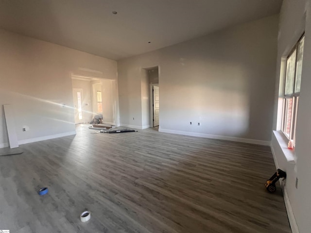 unfurnished living room with wood finished floors and baseboards