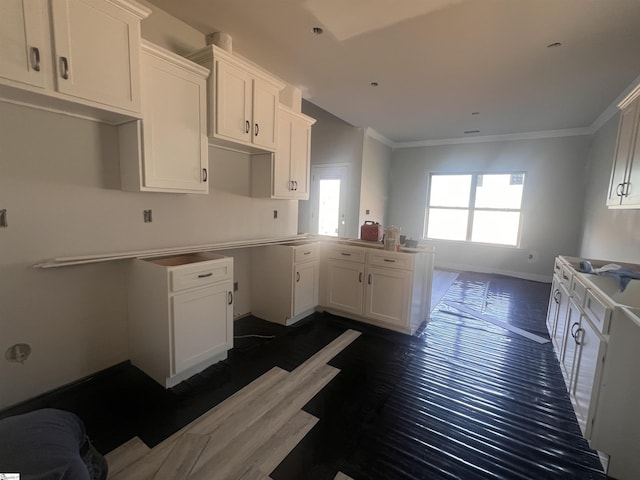 kitchen with baseboards, ornamental molding, dark wood finished floors, and white cabinets