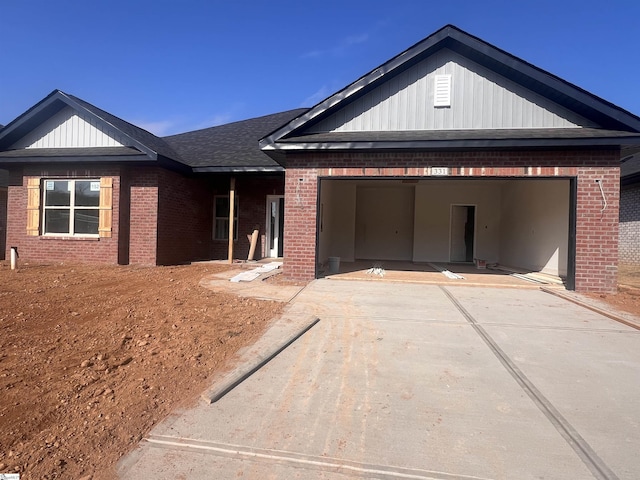 view of front of property featuring concrete driveway, brick siding, an attached garage, and roof with shingles