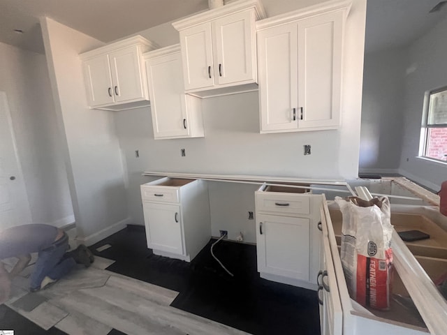 kitchen featuring dark wood finished floors, white cabinetry, and baseboards