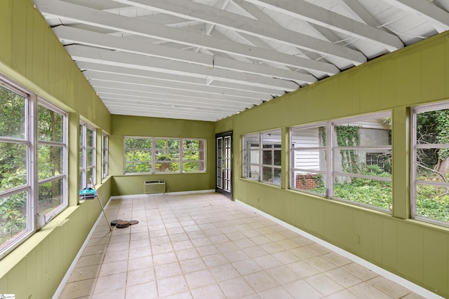 unfurnished sunroom with an AC wall unit and vaulted ceiling with beams