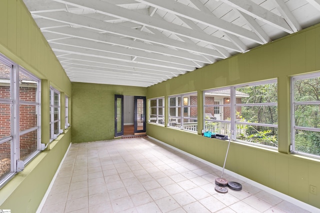 unfurnished sunroom with vaulted ceiling with beams