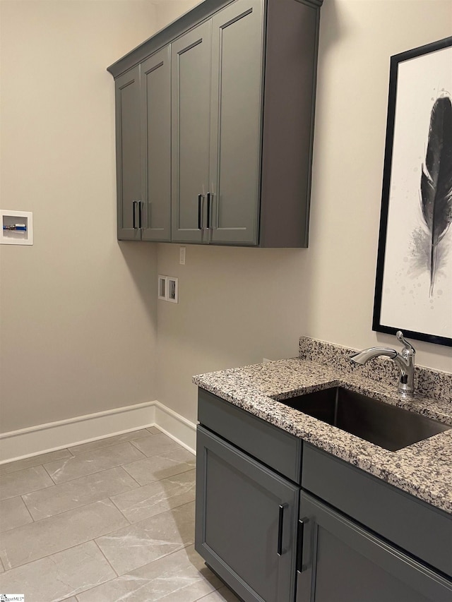 clothes washing area featuring cabinets, washer hookup, and sink