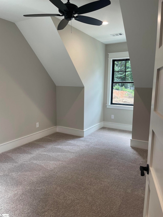 additional living space with vaulted ceiling, light carpet, and ceiling fan