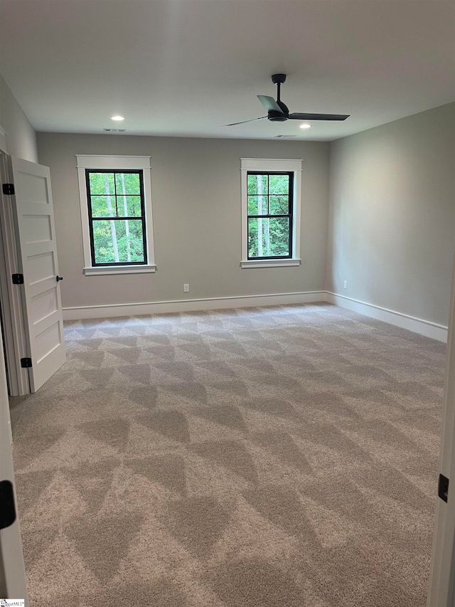 spare room featuring ceiling fan and light carpet