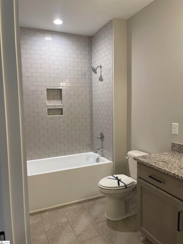 full bathroom featuring tiled shower / bath, vanity, toilet, and tile patterned flooring