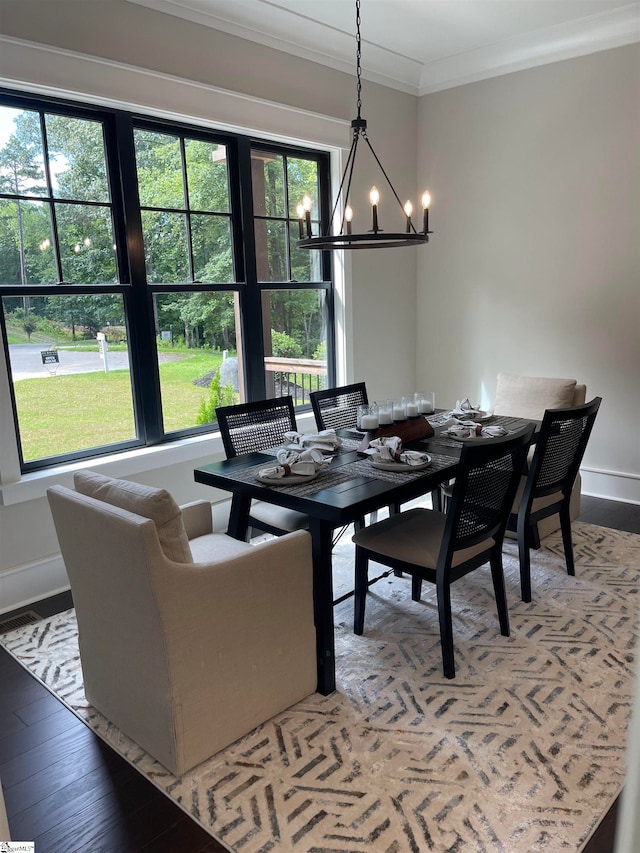 dining area with an inviting chandelier, ornamental molding, and wood-type flooring