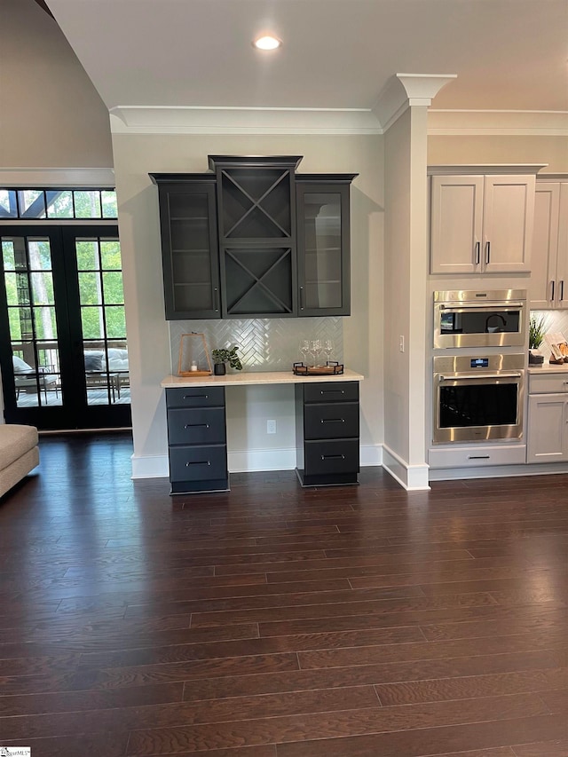 bar featuring backsplash, ornamental molding, and dark hardwood / wood-style floors