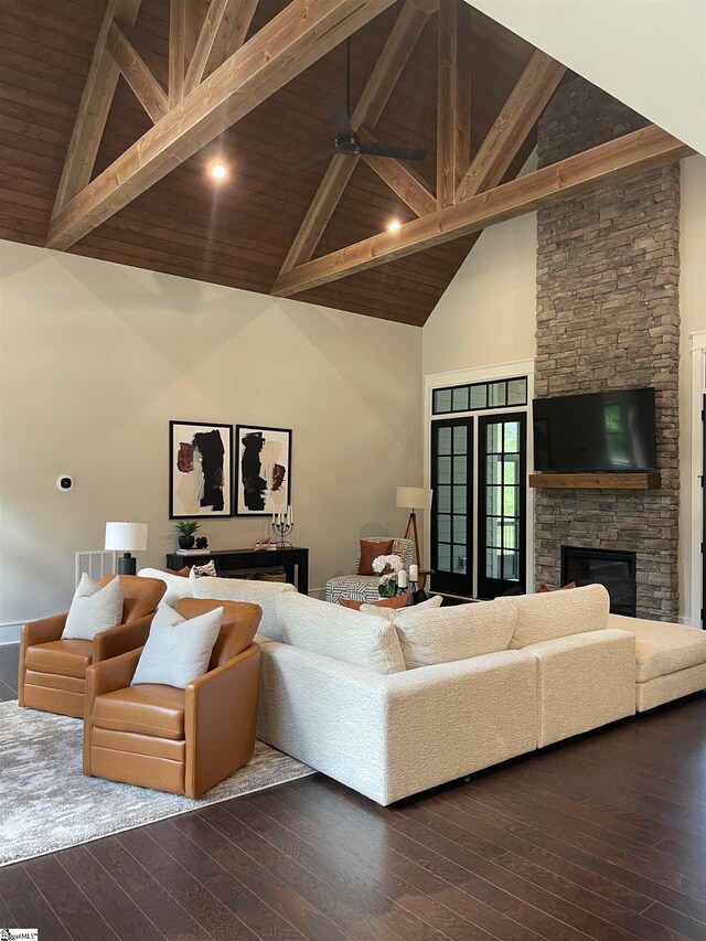 living room featuring beam ceiling, dark hardwood / wood-style flooring, and a fireplace