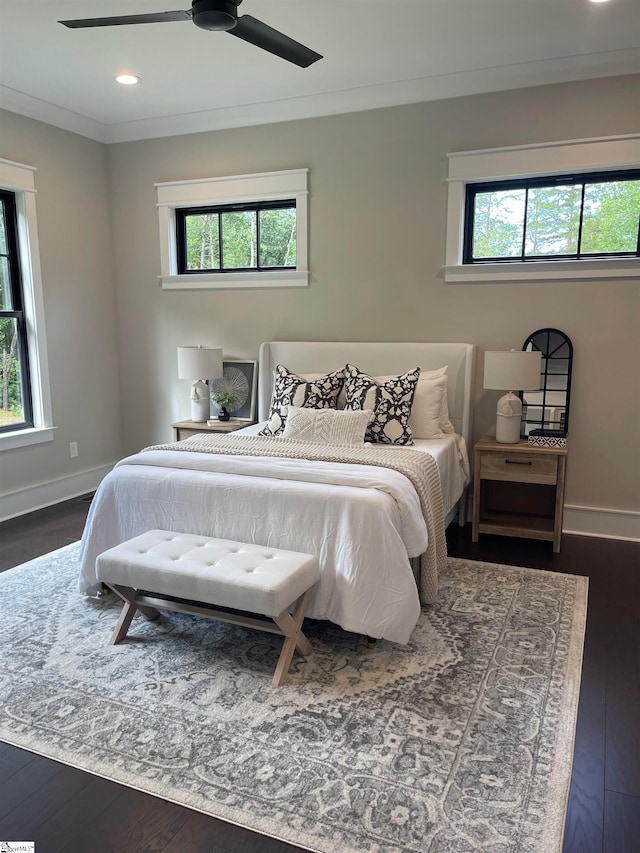 bedroom featuring crown molding, dark wood-type flooring, and ceiling fan