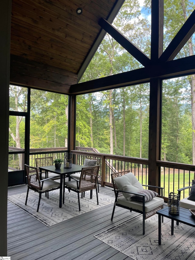 unfurnished sunroom featuring lofted ceiling, wooden ceiling, and a healthy amount of sunlight