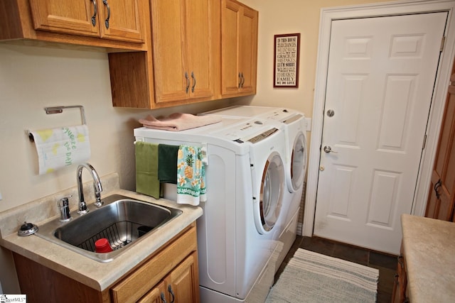 clothes washing area with cabinets, washing machine and clothes dryer, tile patterned floors, and sink