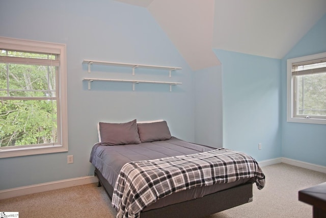 bedroom with multiple windows, lofted ceiling, and light colored carpet