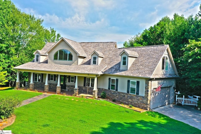 view of front of house featuring a garage, covered porch, and a front lawn