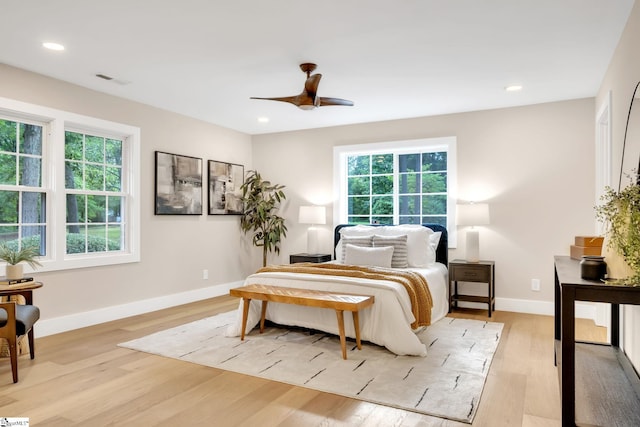 bedroom featuring multiple windows, light wood-type flooring, and ceiling fan