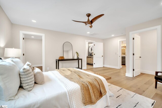 bedroom with ceiling fan, a spacious closet, light hardwood / wood-style floors, a closet, and ensuite bath