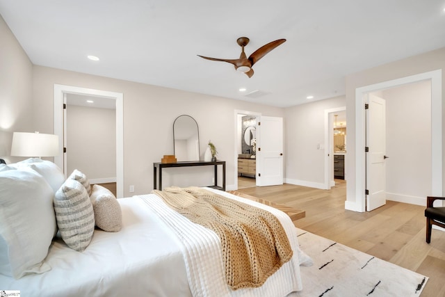 bedroom with ceiling fan, ensuite bathroom, and light hardwood / wood-style flooring