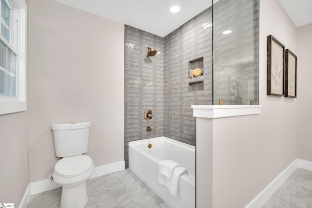 bathroom with tiled shower / bath combo and toilet