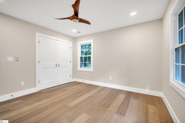 unfurnished bedroom featuring ceiling fan, light hardwood / wood-style floors, and a closet