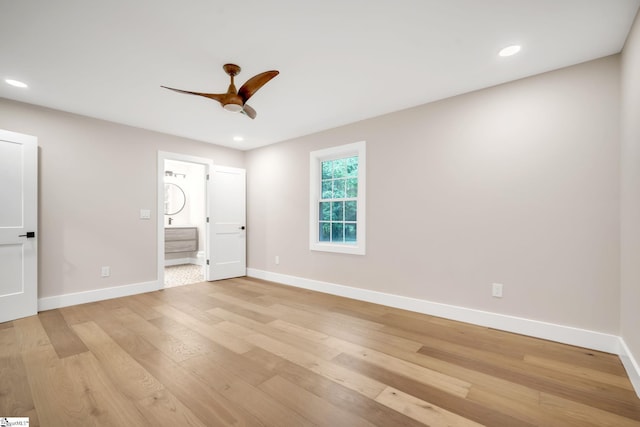 unfurnished bedroom featuring light wood-type flooring, ceiling fan, and connected bathroom