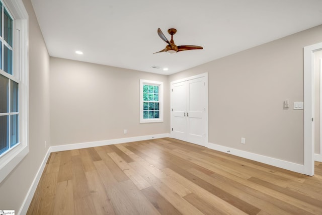 empty room with ceiling fan and light hardwood / wood-style floors