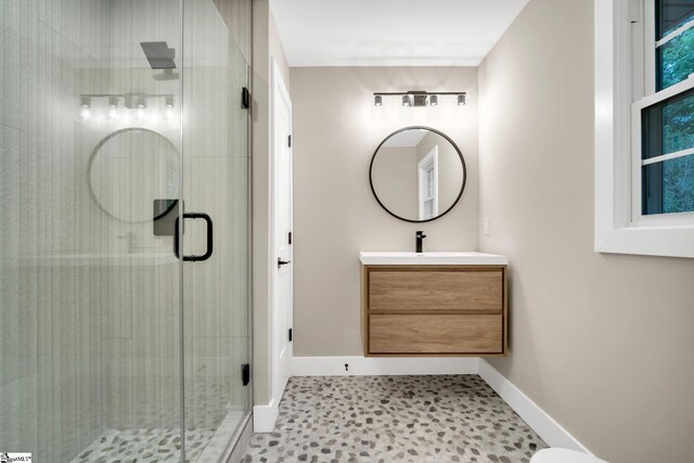 bathroom with a shower with door, vanity, and tile patterned flooring