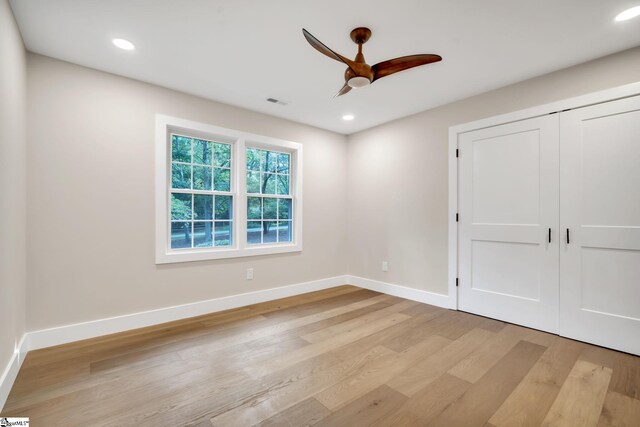 unfurnished bedroom featuring light hardwood / wood-style flooring, a closet, and ceiling fan