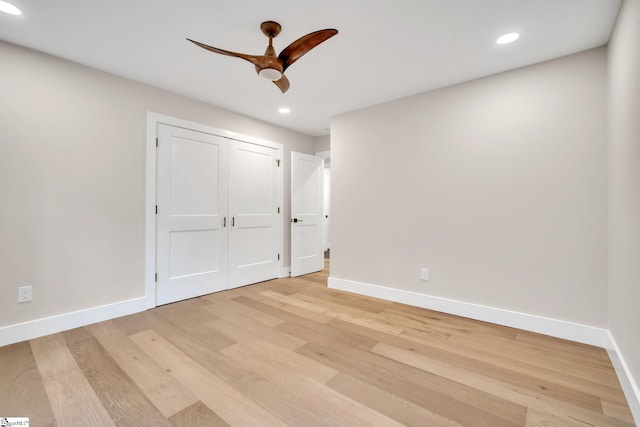 unfurnished bedroom featuring light hardwood / wood-style flooring, a closet, and ceiling fan