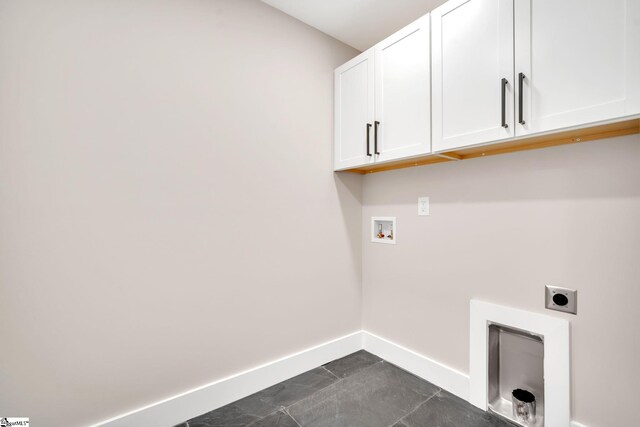 laundry area with cabinets, hookup for an electric dryer, dark tile patterned flooring, and washer hookup