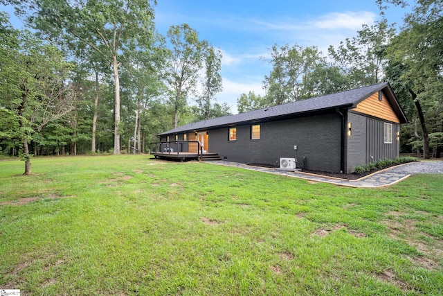 rear view of property with a lawn and a deck