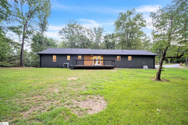 rear view of house featuring central AC unit, a yard, and a deck