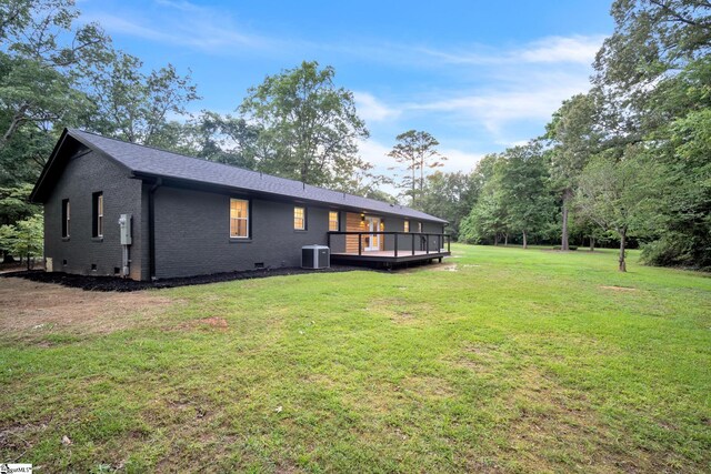 rear view of house with a wooden deck, a lawn, and central AC unit