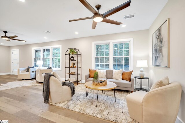 living room with light wood-type flooring and ceiling fan