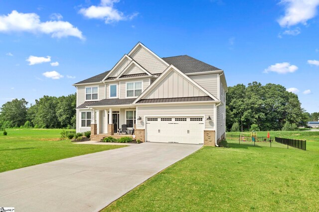 craftsman inspired home with a garage, covered porch, and a front yard