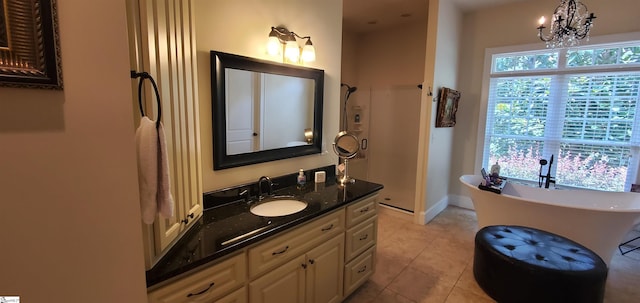 bathroom featuring vanity, a chandelier, tile patterned flooring, and a bathing tub