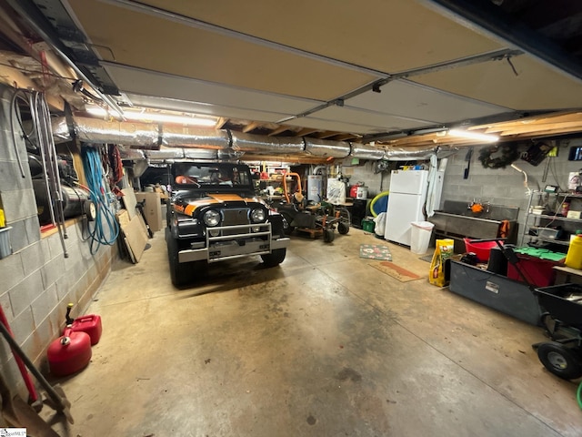 garage with white fridge and water heater