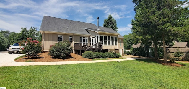 rear view of property with a lawn and a wooden deck