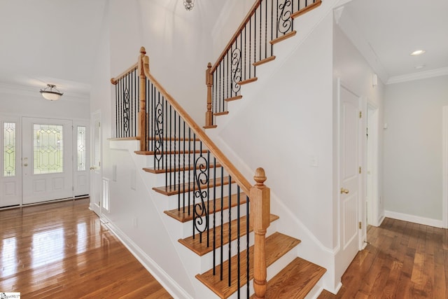 stairway with hardwood / wood-style flooring and ornamental molding