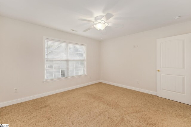 spare room featuring light colored carpet and ceiling fan