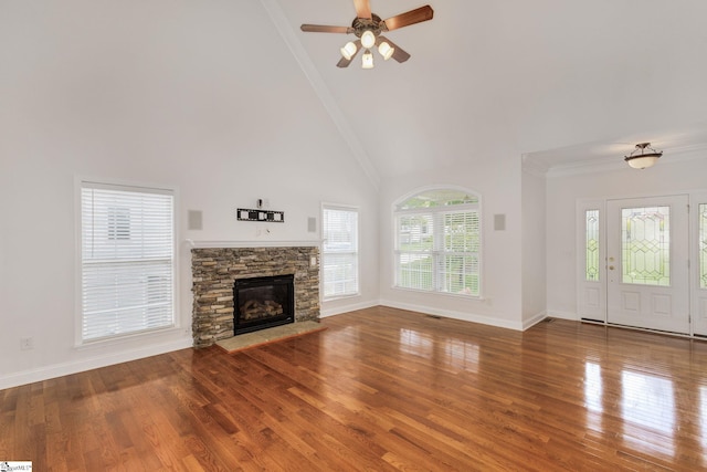 unfurnished living room featuring ornamental molding, a fireplace, ceiling fan, and hardwood / wood-style floors