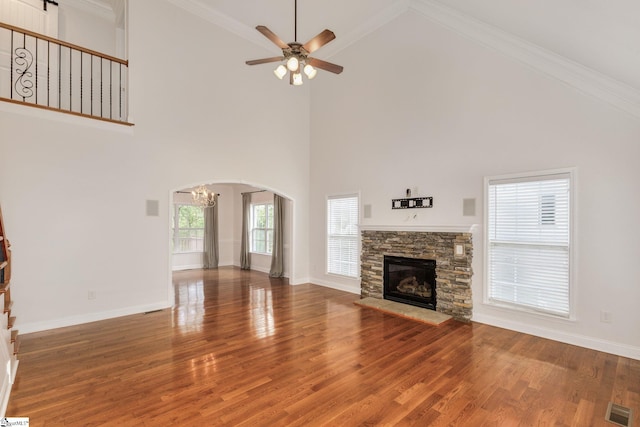 unfurnished living room with ornamental molding, hardwood / wood-style floors, a fireplace, and high vaulted ceiling