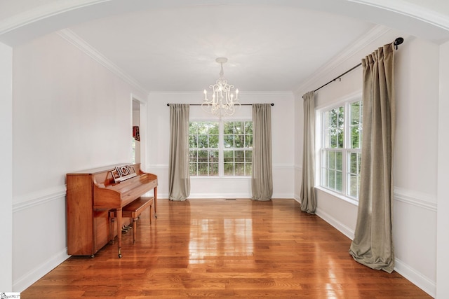 dining space with an inviting chandelier, wood-type flooring, and crown molding