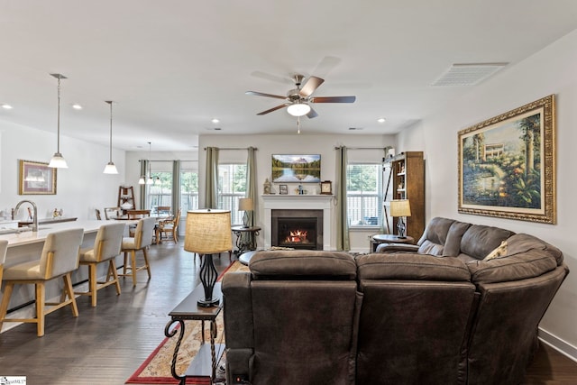 living room with sink, dark hardwood / wood-style flooring, and ceiling fan