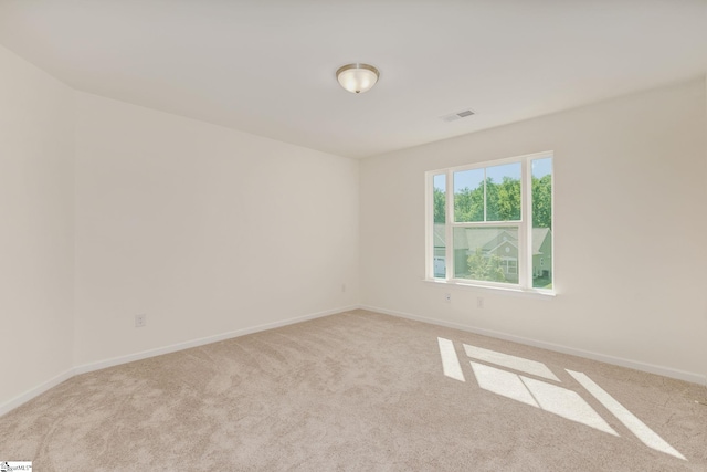 spare room featuring light colored carpet