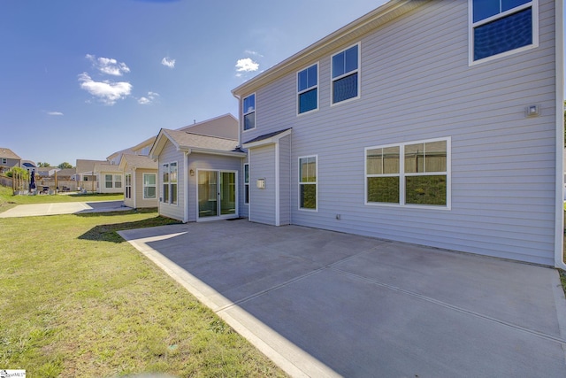 rear view of property with a yard and a patio